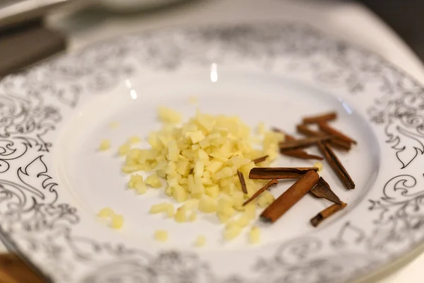 Closeup of chopped ginger and cinnamon sticks on a plate — Stock Photo, Image