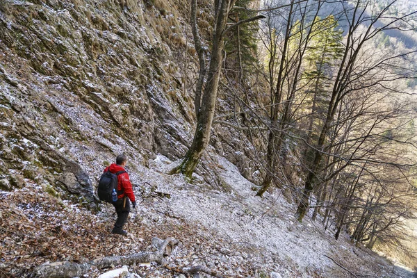 Hombre con mochila senderismo en las montañas rocosas — Foto de Stock