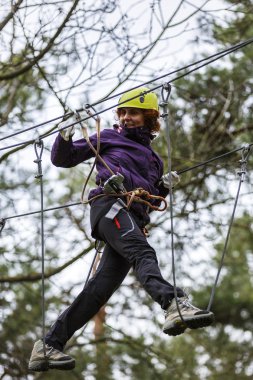 Macera parkında kablolu bir kadın zor bir kursta