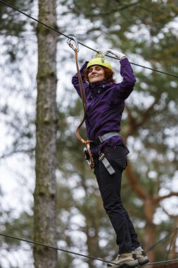 Macera parkında kablolu bir kadın zor bir kursta
