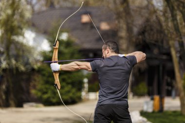 Adam onun yay ile açık bir mesafeden çekim
