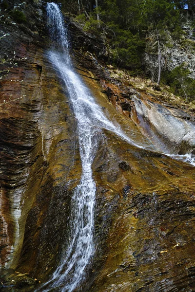 Landscape with a waterfall on colorful rocks — Stock Photo, Image