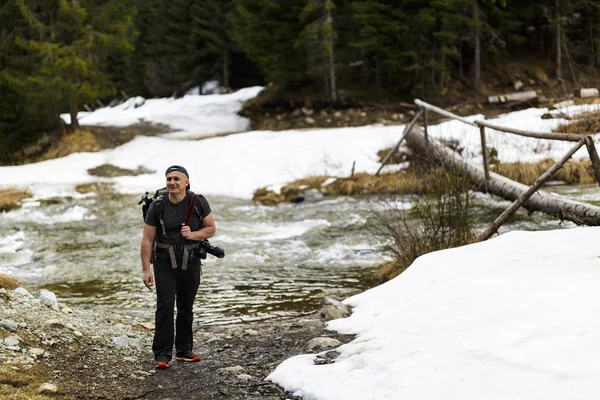 Un excursionista caminando al lado de un pequeño río en un bosque —  Fotos de Stock