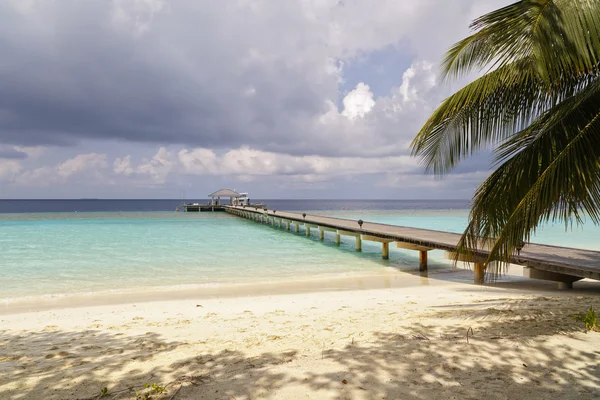 Pomost do trochę tropikalnej wyspy w turkus Oceanu Indyjskiego, Malediwy, sposobem podróży — Zdjęcie stockowe