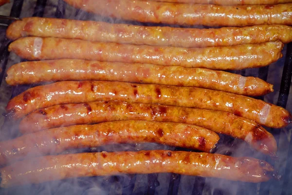 Свежая колбаса и хот-доги на открытом воздухе на газовом барбекю g — стоковое фото