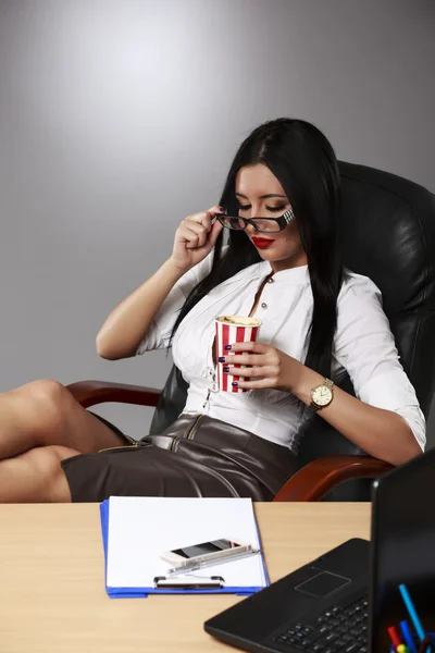 Portrait d'une jeune femme d'affaires détendue assise avec les jambes sur d — Photo