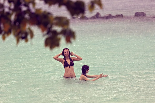 Gente disfrutando de una cálida lluvia en el océano —  Fotos de Stock