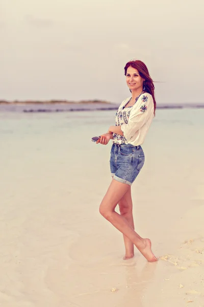 Een mooie vrouw op een tropisch strand — Stockfoto