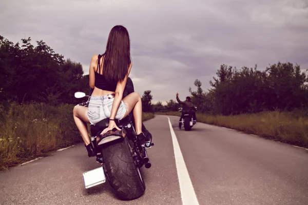 Bela jovem mulher posando com uma motocicleta — Fotografia de Stock