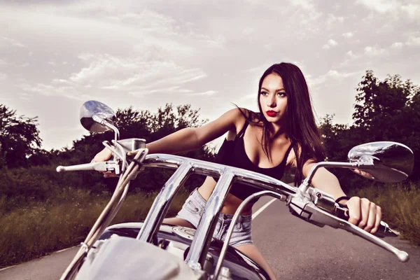 Красива молода жінка позує з мотоциклом — стокове фото