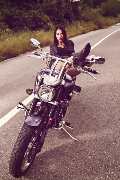 Güzel genç bir kadın motosikletle poz veriyor. — Stok fotoğraf