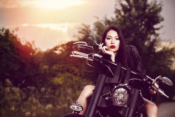 Imagen vintage de una hermosa mujer sentada en una motocicleta y s —  Fotos de Stock