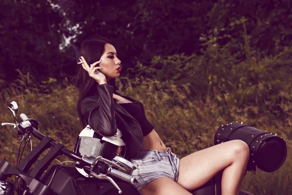 Vintage image of a beautiful woman sitting on a motorcycle and s — Stock Photo, Image