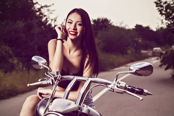 Krásná mladá žena pózuje s motocyklem — Stock fotografie