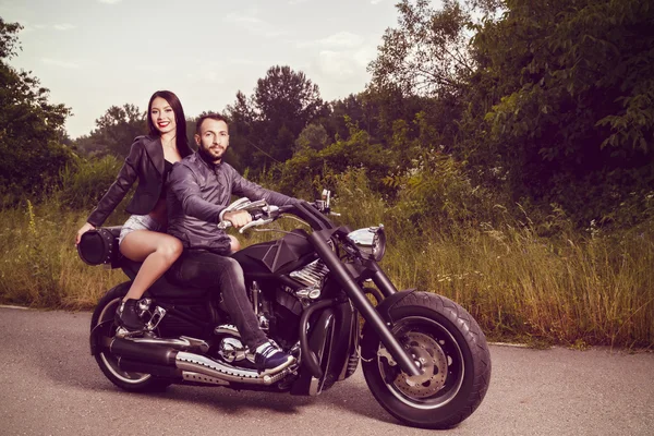 Imagem romântica com um par de belos jovens motociclistas — Fotografia de Stock