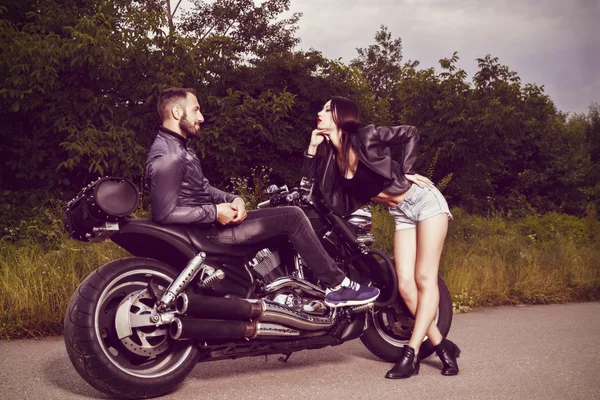 Imagem romântica com um par de belos jovens motociclistas — Fotografia de Stock