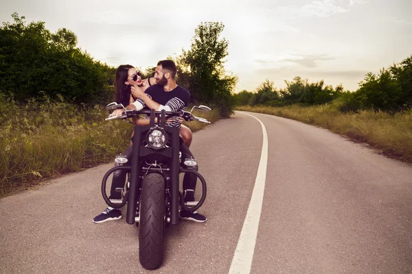 Imagem romântica com um par de belos jovens motociclistas — Fotografia de Stock