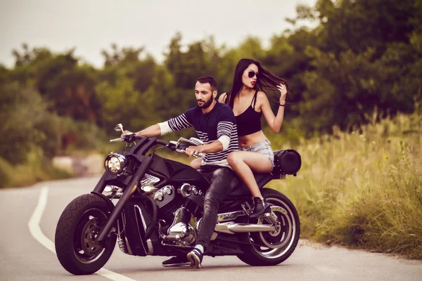 Imagem romântica com um par de belos jovens motociclistas — Fotografia de Stock