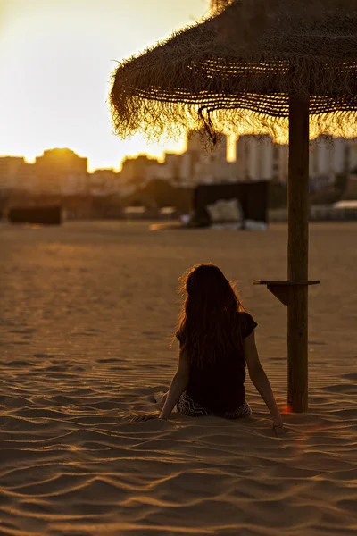 Chica que se ve una puesta de sol en la playa a la ciudad —  Fotos de Stock