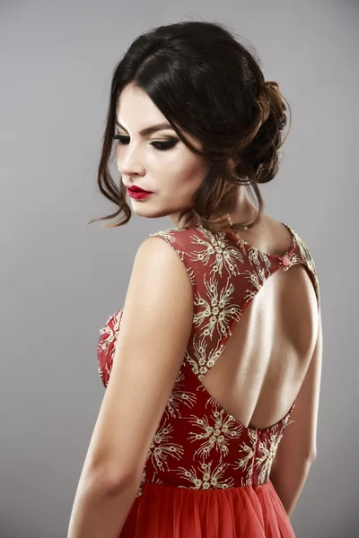 Portret van een mooie jonge vrouw in rode jurk. — Stockfoto