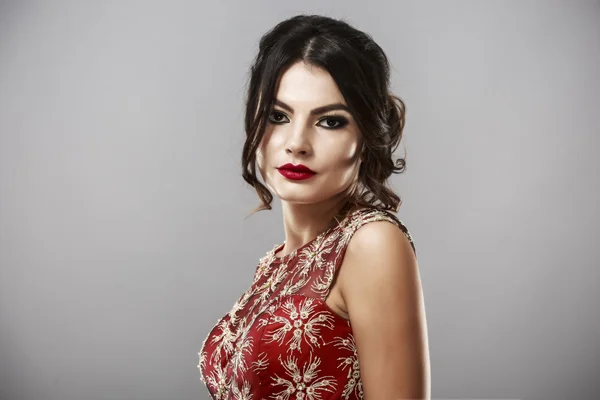 Porträt einer schönen jungen Frau im roten Kleid. — Stockfoto