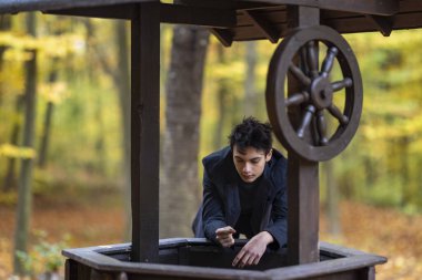 Sonbahar ormanında yakışıklı bir genç adamla portre, moda konsepti..