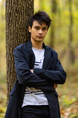 Sonbahar ormanında yakışıklı bir genç adamla portre, moda konsepti..