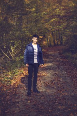 Sonbahar ormanında yakışıklı bir genç adamla portre, moda konsepti..