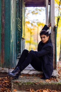 Sonbahar ormanında yakışıklı bir genç adamla portre, moda konsepti..