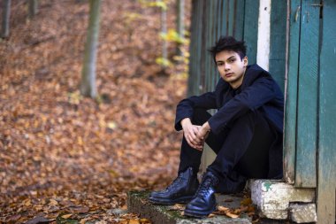 Sonbahar ormanında yakışıklı bir genç adamla portre, moda konsepti..