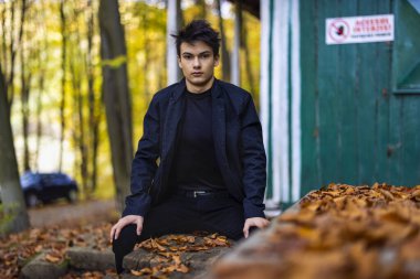 Sonbahar ormanında yakışıklı bir genç adamla portre, moda konsepti..