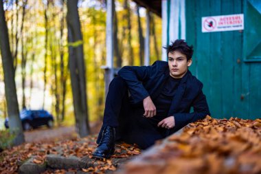 Sonbahar ormanında yakışıklı bir genç adamla portre, moda konsepti..