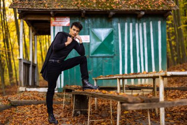 Sonbahar ormanında yakışıklı bir genç adamla portre, moda konsepti..