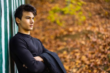 Sonbahar ormanında yakışıklı bir genç adamla portre, moda konsepti..