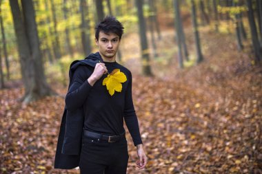 Sonbahar ormanında yakışıklı bir genç adamla portre, moda konsepti..