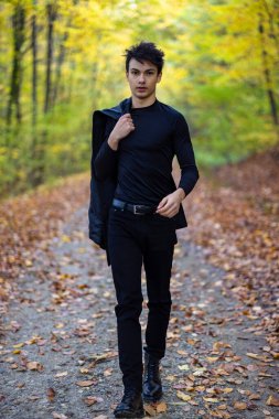 Sonbahar ormanında yakışıklı bir genç adamla portre, moda konsepti..