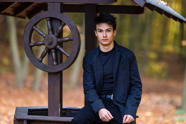 Sonbahar ormanında yakışıklı bir genç adamla portre, moda konsepti..