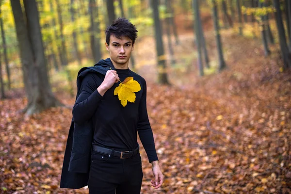 Sonbahar ormanında yakışıklı bir genç adamla portre, moda konsepti..