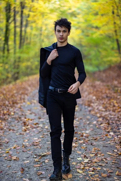 Sonbahar ormanında yakışıklı bir genç adamla portre, moda konsepti..