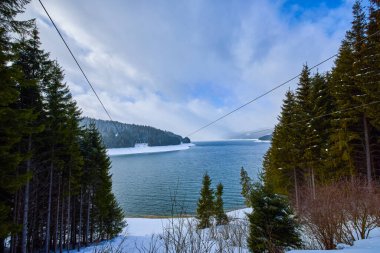 Kışın dağlarda gölü olan bir manzara