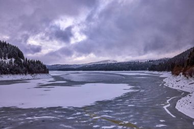 Kışın dağlarda gölü olan bir manzara