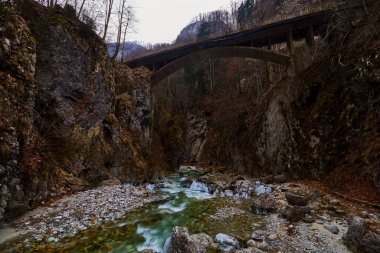 Kanyonda kış günü küçük şelaleleri olan bir dağ nehri olan güzel bir manzara..