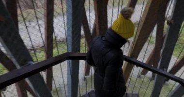 Gözetleme noktasının dairesel merdivenlerinden inen bir kadının arka görüntüsü..