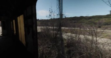 Terk edilmiş bir tren vagonunun içinde el kamerasıyla çekilmiş.