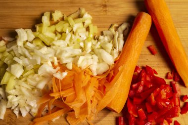 Öğütücüdeki sebzelerin çeşitliliği. Yeşil dolma biber, kırmızı dolma biber, havuç, soğan.