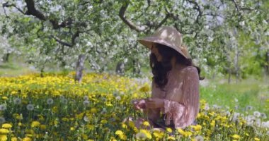 Bahar elması bahçesinde doğanın tadını çıkaran güzel genç bir kadın çiçek açan ağaçları olan mutlu, güzel bir kız..