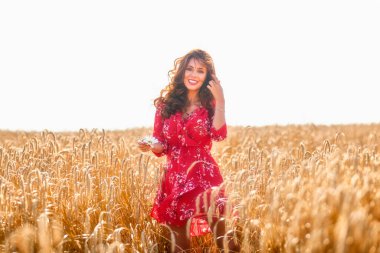 Güneşli bir yaz gününde, buğday tarlasında güzel bir kadın.