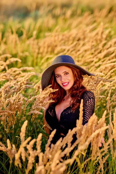 Beautiful Brunette Woman Hat Poses Grass Sunset — Stock Photo, Image