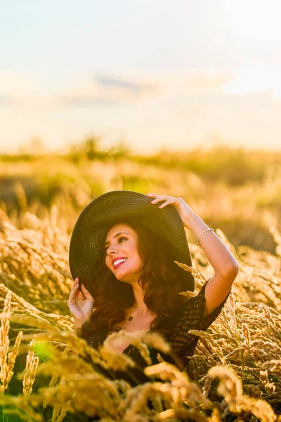 Piękna Brunetka Kobieta Kapeluszem Pozuje Trawie Zachodzie Słońca — Zdjęcie stockowe