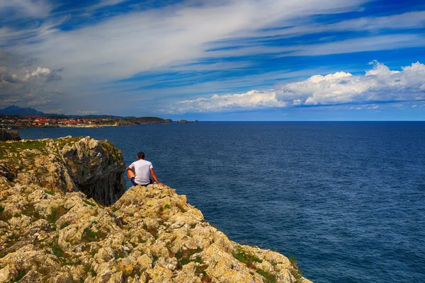 Turista che guarda una città sulla riva del mare alto — Foto Stock